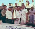 August 30, 1959 Milwaukee Mile. Victory Lane. Driver Rodger Ward receives the Leader Card Trophy from Leader Card car owner Bob Wilke and the guy that makes it happen AJ Watson on the right. Ward started 19th and lead 52 laps. Ward also won the 100 lap midget race the day before in the Ralph Wilke midget.