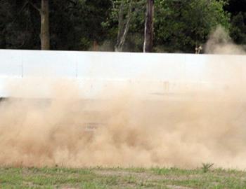 A cloud of dust surrounds a spun car.