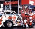 1992 Indianapolis, IN Driver Page Jones with the Wilke Racers, Ellis pavement car,smiles with the Hooters girls for a promotional photo.

