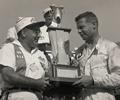 June 7, 1959 Milwaukee Mile. Bob Wilke presents Johnny Thomson with the Leader Card Trophy after winning the big car race. Thomson took the lead from Leader Card ace Rodger Ward with two laps to go when Ward fell out of the race.