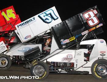 Shane Stewart (57) and Paul McMahan (3d) fight for the lead in the Friday night opener