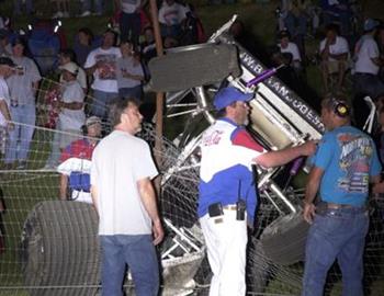 The hillside crowd looks on as track officials discuss fence repair following a wild ride by Bryan Dobesh
