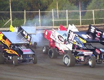 Darren Stewart (91) and Eric Baldaccini (b4) lead a heat race off turn four