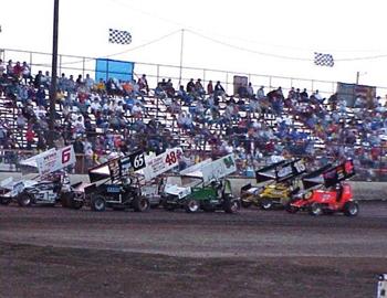 The first heat race paces in front of the crowded bleachers