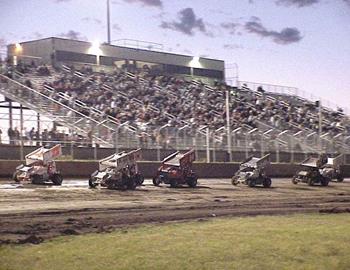 A heat race parades past the Junction Motor Speedway grandstands