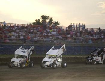 Danny Wood (94), Sherman Davis (72) and Paul McMahan (3d) race down the frontstretch in front of a packed house