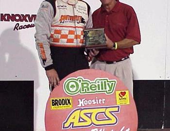 Emmett Hahn presents Gary Wright with a plaque and feature board commemorating 100 wins