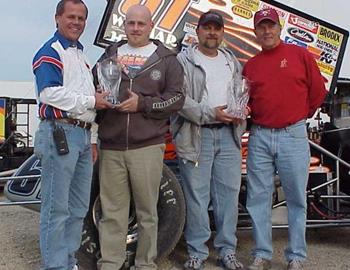 Tommie Estes, Jr. (left) and Emmett Hahn (right) present Toby and Terry Brown with special awards for their 200th consecutive event.