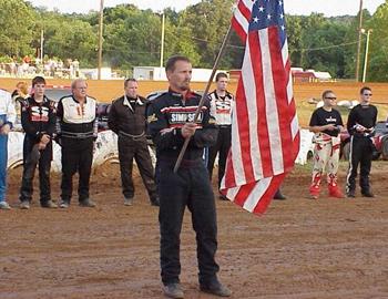 Tim Crawley holds the flag during opening ceremonies