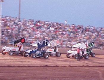 Earnest Jennings (61) and Gary Owens (33) lead a heat race in front of a packed house at Lawton